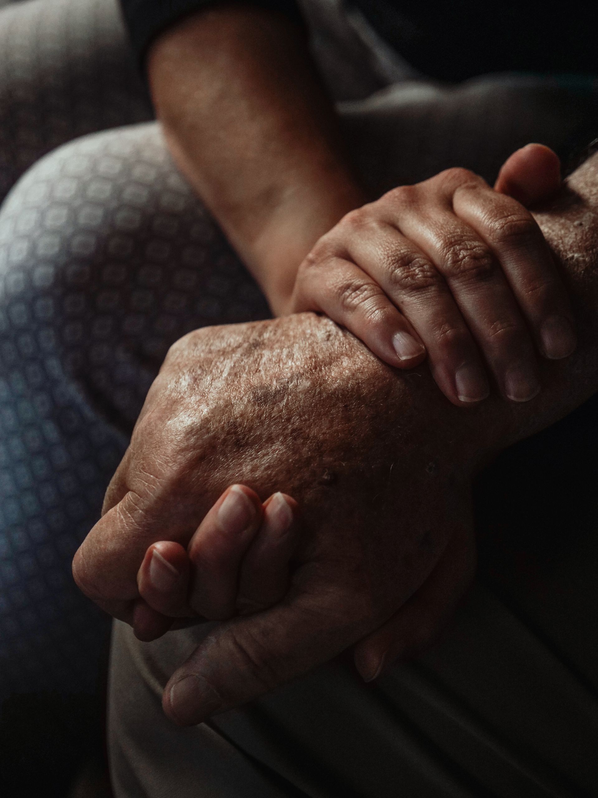 Our Story A touching close-up of hands symbolizing support and compassion between generations.