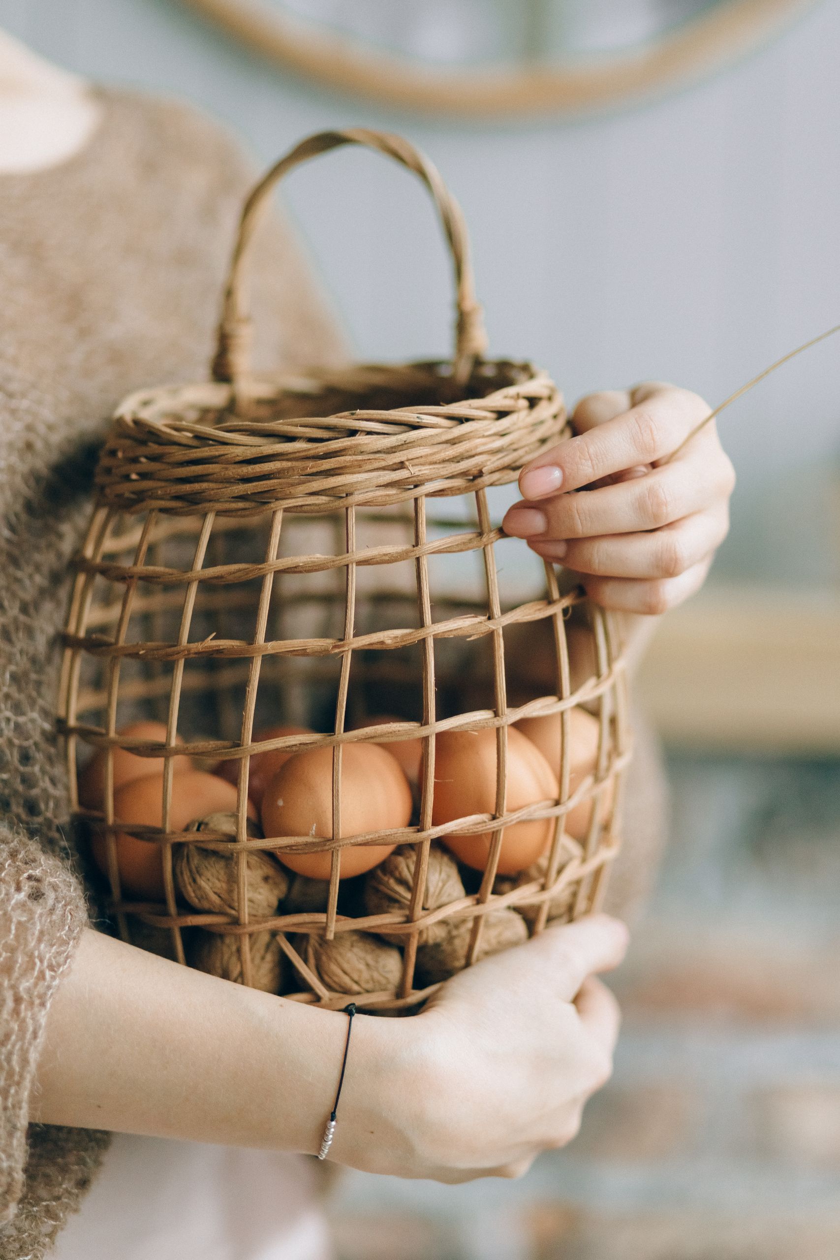 Our Story Cozy Easter basket decor featuring painted eggs and pinecones by candlelight.