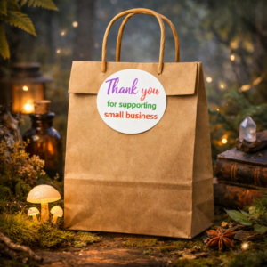 kraft handled bag sealed with a “Thank you for supporting small business” sticker, surrounded by apothecary elements in a forest‑enchantment setting